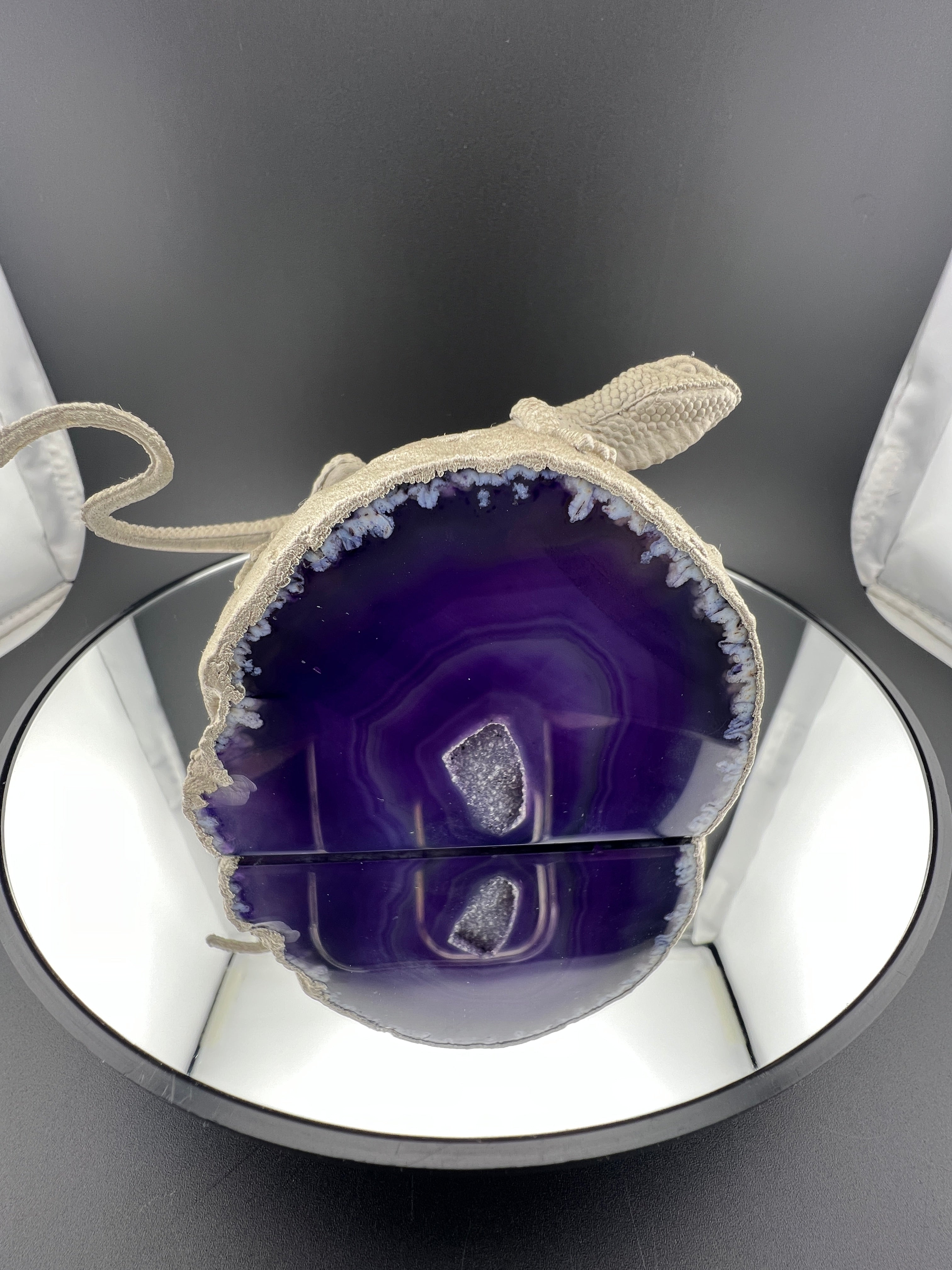 Purple agate stone with silver lace on a reflective surface